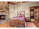 Cozy bedroom featuring a stone fireplace, wood accents and a decorative chandelier at 220 Cottonwood Cir, Breckenridge, CO 80424