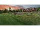 Expansive home exterior with large lawn and landscaping at sunset, providing a peaceful mountain setting at 220 Cottonwood Cir, Breckenridge, CO 80424