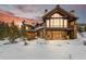 Stunning sunset view of the house showing its architecture, large windows, and natural surroundings at 220 Cottonwood Cir, Breckenridge, CO 80424