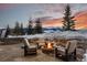 Outdoor seating with a firepit, set against a breathtaking mountain view at twilight at 220 Cottonwood Cir, Breckenridge, CO 80424