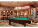 Entertainment room features a pool table, stone accent walls, custom lighting, and adjacent wet bar at 220 Cottonwood Cir, Breckenridge, CO 80424