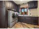 Laundry room featuring dark cabinets, granite countertops, and modern washer/dryer units at 220 Cottonwood Cir, Breckenridge, CO 80424