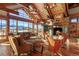 Bright living room with vaulted wood ceilings, stone fireplace, floor to ceiling windows, and mountain views at 220 Cottonwood Cir, Breckenridge, CO 80424