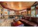 Expansive living room with stone accents, wood ceiling, leather sectional, fireplace, and adjacent dining/game area at 220 Cottonwood Cir, Breckenridge, CO 80424