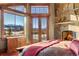 Bright main bedroom featuring a stone fireplace, private balcony, and scenic mountain views at 220 Cottonwood Cir, Breckenridge, CO 80424