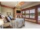 Cozy main bedroom with fireplace, brick accent wall, scenic mountain views, and elegant chandelier at 220 Cottonwood Cir, Breckenridge, CO 80424