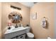 Bathroom featuring a white vanity, decorative mirror, toilet, and light fixtures at 225 Briscoe Ln, Castle Rock, CO 80109