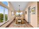 Sunlit dining room features a rustic wooden table set, showcasing scenic views from large windows at 225 Briscoe Ln, Castle Rock, CO 80109