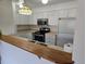 Kitchen featuring white cabinets, stainless steel appliances, and breakfast bar at 14500 E 2Nd Ave # 209A, Aurora, CO 80011