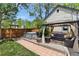 Backyard featuring a hot tub, patio with seating, pergola, and lush landscaping at 300 E Cleveland St, Lafayette, CO 80026