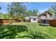Spacious backyard with lush green grass, a trampoline, hot tub, and a storage shed surrounded by trees and a fence at 300 E Cleveland St, Lafayette, CO 80026