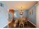 Cozy dining room features wood floors, a unique light fixture, and a charming wood table with bench and chairs at 460 S Marion Pkwy # 251, Denver, CO 80209