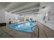 A well-lit indoor pool with clear blue water, surrounded by comfortable seating and large windows for a serene atmosphere at 460 S Marion Pkwy # 251, Denver, CO 80209