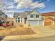 Charming two-story home with blue paint, brick facade, and a spacious driveway at 1057 English Sparrow Trl, Highlands Ranch, CO 80129