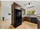Well-appointed kitchen with black appliances, dark wood cabinetry, granite countertops, and hardwood floors at 7345 W 97Th Pl, Broomfield, CO 80021