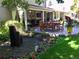Serene backyard featuring a stone water feature, covered patio with dining, and lush landscaping at 2134 S Jackson St, Denver, CO 80210