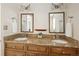 Bathroom featuring a double sink vanity with granite countertops and decorative mirrors at 2134 S Jackson St, Denver, CO 80210