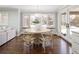 Bright dining room with hardwood floors, round table, and bay window overlooking the lush backyard at 2134 S Jackson St, Denver, CO 80210