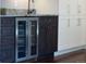 Close up of a beverage fridge with custom cabinets and bronze hardware at 2134 S Jackson St, Denver, CO 80210
