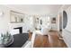 Open-concept living room and dining area with hardwood floors and a fireplace at 2134 S Jackson St, Denver, CO 80210