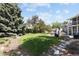 Expansive backyard features a lush lawn, mature trees, and a stone pathway leading to the patio area at 9383 W Colorado Ave, Lakewood, CO 80232