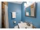 Blue bathroom featuring a shower with a curtain, mirror and sink with neutral tile accents at 9383 W Colorado Ave, Lakewood, CO 80232