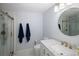 Bright bathroom featuring a tiled shower, white vanity with marble countertop, and a round mirror at 9383 W Colorado Ave, Lakewood, CO 80232