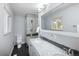 Bright bathroom featuring a double sink vanity with marble countertops, a glass-enclosed shower, and modern fixtures at 9383 W Colorado Ave, Lakewood, CO 80232