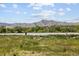 A serene walking trail winds around a tranquil lake with mountain views in the distance at 9383 W Colorado Ave, Lakewood, CO 80232