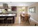Open kitchen and dining area with stainless steel appliances, quartz countertops, hardwood floors, and stylish decor at 9383 W Colorado Ave, Lakewood, CO 80232