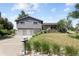 Attractive home with a sloped lawn, mature trees, a two-car garage, and a gray exterior at 9383 W Colorado Ave, Lakewood, CO 80232