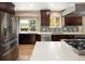 Kitchen features stainless appliances, quartz countertops, wood floors, and a view from the large window at 9383 W Colorado Ave, Lakewood, CO 80232