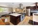 Open kitchen boasts a light blue stove, stainless appliances, wood floors, and center island with quartz countertops at 9383 W Colorado Ave, Lakewood, CO 80232