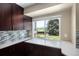 Bright kitchen features a large window overlooking the landscaped backyard and stainless appliances at 9383 W Colorado Ave, Lakewood, CO 80232