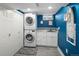 Well-lit laundry room includes modern washer and dryer set, utility sink, and storage cabinetry at 9383 W Colorado Ave, Lakewood, CO 80232