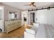 Bright main bedroom with dresser, mirrors, hardwood floors, and a king-size bed with decor at 9383 W Colorado Ave, Lakewood, CO 80232