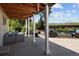 Covered patio with stone flooring, outdoor seating, and views of the landscaped backyard and fire pit at 9383 W Colorado Ave, Lakewood, CO 80232