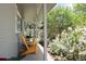 Cozy covered porch featuring two yellow Adirondack chairs and a view of the lush garden at 9383 W Colorado Ave, Lakewood, CO 80232
