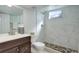 Bathroom featuring marble tile shower, stone floor, new fixtures, sink and vanity at 230 W 78Th Pl, Denver, CO 80221