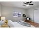 Light bedroom featuring hardwood floors, a ceiling fan, stylish chair, and a view from the window at 230 W 78Th Pl, Denver, CO 80221
