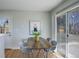 Bright dining area featuring sliding glass doors leading to backyard, and mid-century modern table and chairs at 230 W 78Th Pl, Denver, CO 80221
