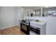 Stylish kitchen featuring stainless steel appliances, gray cabinets and hardwood floors at 230 W 78Th Pl, Denver, CO 80221