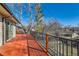 A wooden back deck boasts black metal railings and views of the neighborhood at 6534 Field St, Arvada, CO 80004