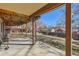 Covered patio with exposed beams offers an outdoor space overlooking the yard, enclosed by wooden fencing at 6534 Field St, Arvada, CO 80004