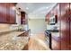 Bright kitchen featuring granite countertops, wood cabinets, stainless steel appliances and hardwood floors at 6534 Field St, Arvada, CO 80004