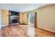 Inviting living room with hardwood floors, a brick fireplace, a mounted TV, and sliding glass doors to an outdoor deck at 6534 Field St, Arvada, CO 80004