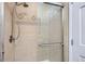 Neutral tiled shower stall with glass door and decorative tile accents at 6534 Field St, Arvada, CO 80004