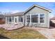 Back of the house features large windows and a patio looking onto the backyard at 312 Las Lomas St, Brighton, CO 80601