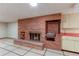 Finished basement fireplace with brick surround and tile floors and kitchenette at 2081 W Ridge Rd, Littleton, CO 80120