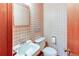 Cozy half bathroom with patterned wallpaper, a small sink, and a standard toilet at 2081 W Ridge Rd, Littleton, CO 80120